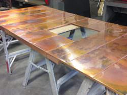 Burnished copper wall panels for fireplace surround