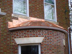 Round standing seam roof section in copper