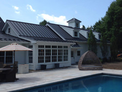 Standing seam matte black aluminum roofing with colorgard snow retention system and single bead gutter