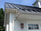 Standing seam matte black aluminum roofing with colorgard snow retention system and single bead gutter - view 6